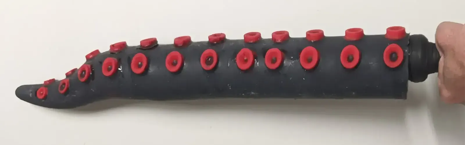 A black tentacle bat with red suckers